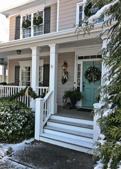 a white house with wreaths on the front porch