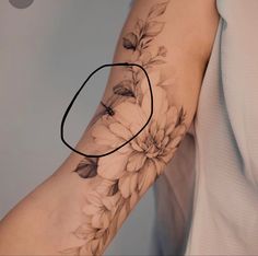 a woman's arm with flowers on it and a circle in the middle that says love