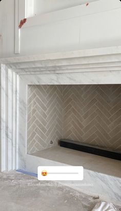 a fireplace with white marble in the middle and an inset on the wall above it