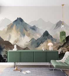 a living room with mountains painted on the wall and a green chair in front of it