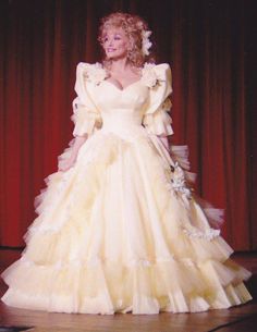 a woman in a yellow dress standing on a stage