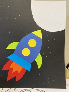 a child's drawing of a rocket ship in space with the moon behind it