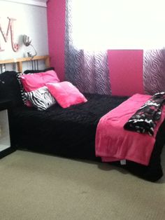 a bedroom with pink and black decor on the walls