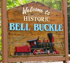 a welcome sign to historic bell bucklee with a train on the front and side