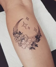 a woman's arm with a flower and crescent tattoo on the left side of her arm