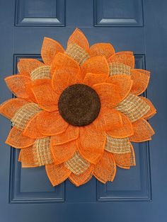 an orange mesh sunflower on a blue door