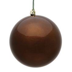 a shiny brown ornament hanging from a green twig on a white background