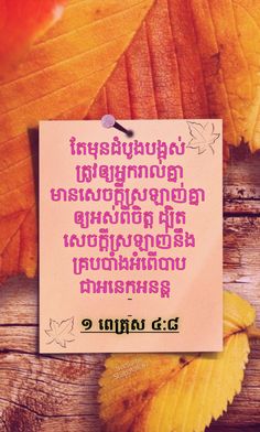 an orange leaf with the words in thai on it next to some yellow and red leaves