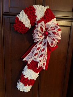 a candy cane wreath is hanging on the front door for someone to make it longer