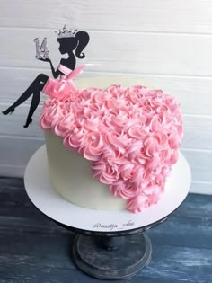 a cake decorated with pink frosting and a silhouette of a woman in a dress