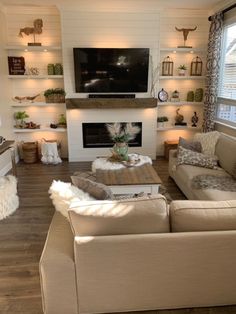 a living room filled with furniture and a flat screen tv mounted on the wall above a fire place