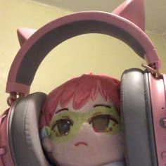 a doll with pink hair and green eyes wearing headphones