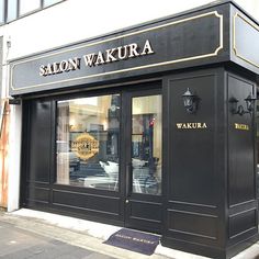 a black store front with gold lettering on the outside and windows that say salon wakura