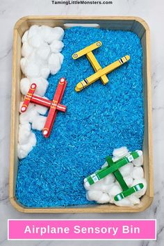 an airplane sensory bin is filled with clouds and toys