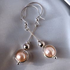 "Sweet statement peach pink, near round baroque pearl drop earrings, each framed with a sterling silver circlet. These lovely peach 8mm pearls have a very high luster, slightly uneven surface that brands them as natural at a glance.  Perfect for a wedding or any other occasion that calls for a feminine, but bold statement. A sterling silver circlet around each repeats the motif of larger and smaller sterling beads for a luxurious, glowing impression in sterling and pearls. Sterling frames spin freely, so these are elegant little fidget earrings toy as well. Earrings full length is about 2.30\", drop part 1.75\". Comes in a gift-ready branded matte black jewelry box." Matte Black Jewelry, Sterling Silver Drop Earrings, Black Jewelry, Pearl Earrings Dangle, Silver Drop Earrings, Agate Pendant, Peach Pink, Pearl Drop Earrings, Pearl Drop