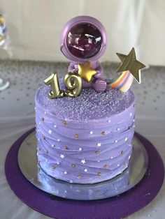 a purple cake with an astronaut on top