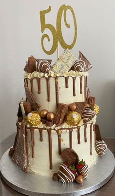 a 50th birthday cake with chocolate drizzles and strawberries