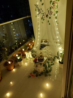 a room filled with lots of plants and candles on the floor next to a window