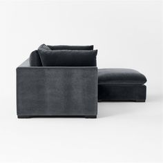 a black couch and ottoman sitting next to each other on a white surface with one arm extended