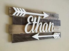 a wooden sign with arrows and the word ethan on it