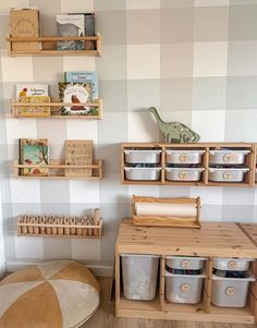 a room with some shelves and baskets on the wall next to a table filled with toys