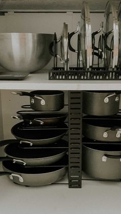 pots and pans are stacked on the shelf