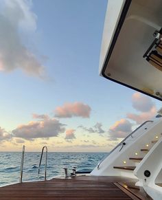 the deck of a boat with stairs leading up to it and water in the background