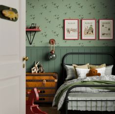 a bed room with a neatly made bed next to a dresser and pictures on the wall