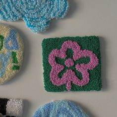 four crocheted coasters with flowers on them