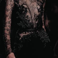 a close up of a person wearing a black dress