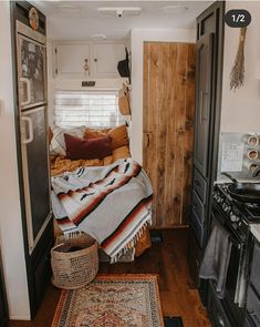 a small bedroom with a bed, rug and stove top oven in front of it