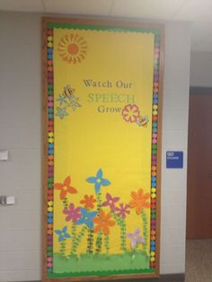 a bulletin board with flowers on it in an office cubicle area that says watch our speech grow