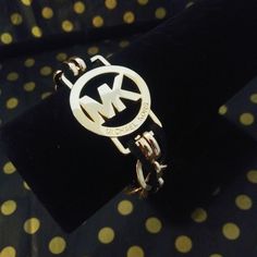 Authentic Michael Kors Logo Charm On A 14k Gold Filled Double Link Chain With Black Cruelty-Free Vegan Faux Suede Lace Woven Throughout Ending With A 14k Gold Filled Square Toggle Clasp Closure. Authentic Mk Logo Charm= 1.25 In Diameter & 1.75 In Length Total Bracelet= 8.5 In Length & 3/4 In Width Note: Loose Toggle Bracelet Fit. This Is A Handmade Upcycled Item Created From Repurposing Authentic Items Sold By Jewelry My Style By Jms. Packaging As Shown In Last Pics. Modern Michael Kors Gold Jewelry, Luxury Jewelry With Metal Logo, Luxury Metal Jewelry With Metal Logo, Elegant Gold-tone Jewelry With Metal Logo, Elegant Michael Kors Metal Jewelry, Michael Kors Formal Metal Jewelry, Formal Michael Kors Metal Jewelry, Lace Weave, Michael Kors Logo