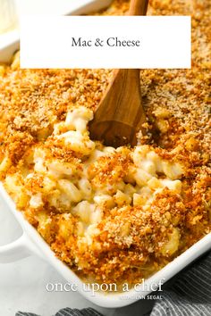 macaroni and cheese in a white casserole dish with a wooden spoon