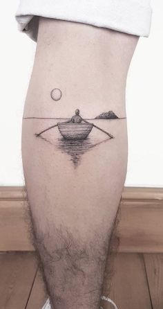 a man's leg with a small boat on it