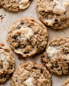 chocolate chip cookies with white crumbs on a piece of parchment paper, ready to be eaten