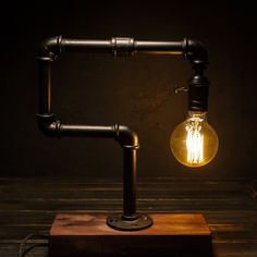 a light bulb sitting on top of a wooden block with pipes coming out of it