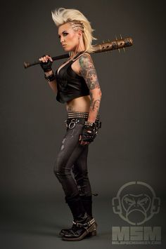 a woman with tattoos and piercings holding a baseball bat in her hand while posing for the camera