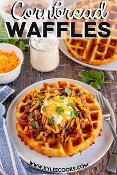 cornbread waffles on a white plate topped with cheese and sour cream