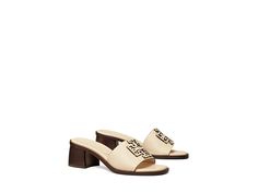 Tory Burch Ines Heeled Sandal 55 mm - Women's Shoes : New Cream : The Tory Burch Ines Heeled Sandal is the perfect finishing touch for any outfit. Slip-on mule style. Open toed design. Branded design on top of vamp. Round toe silhouette. Bovine leather uppers. Sheep leather linings. Chunky stacked heel. Bovine leather and rubber outsoles. Imported. Measurements: Heel Height: 2 1 6 in Product measurements were taken using size 8, width M. Please note that measurements may vary by size. Weight of Cream Mules, Sandals With Heels, Tory Burch Sandals, Slip On Mules, Heeled Sandal, Sheep Leather, Stacked Heel, Mule Shoe, Women's Shoes