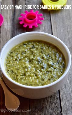 a white bowl filled with green liquid next to toys on a wooden table and text overlay that reads easy spinach rice for babies & toddlers