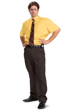 a man in a yellow shirt and tie standing with his hands on his hips while looking at the camera