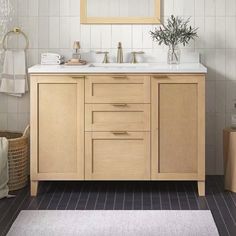 a bathroom vanity with two sinks and a large mirror over the sink, in front of a white tiled wall