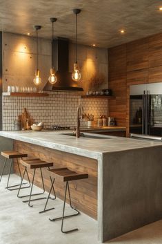 a kitchen with an island and stools in front of the counter top that is made out of concrete