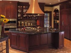 a large kitchen with wooden cabinets and granite counter tops, along with an island in the middle