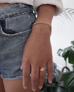 a person wearing a gold bracelet and a white shirt