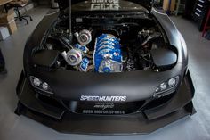 the engine compartment of a sports car in a garage