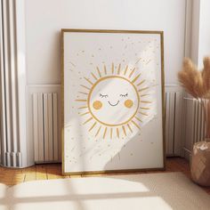 a white and gold framed art print with a smiling sun on it's face