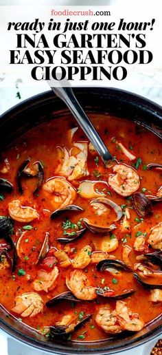 a pan filled with seafood and clams in tomato sauce