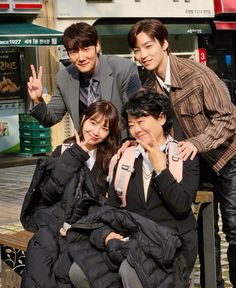 three young people posing for a photo on a bench